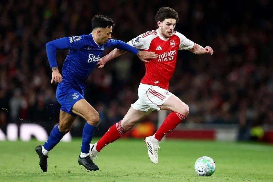 Arsenal player dribbling past Everton defender during Premier League match